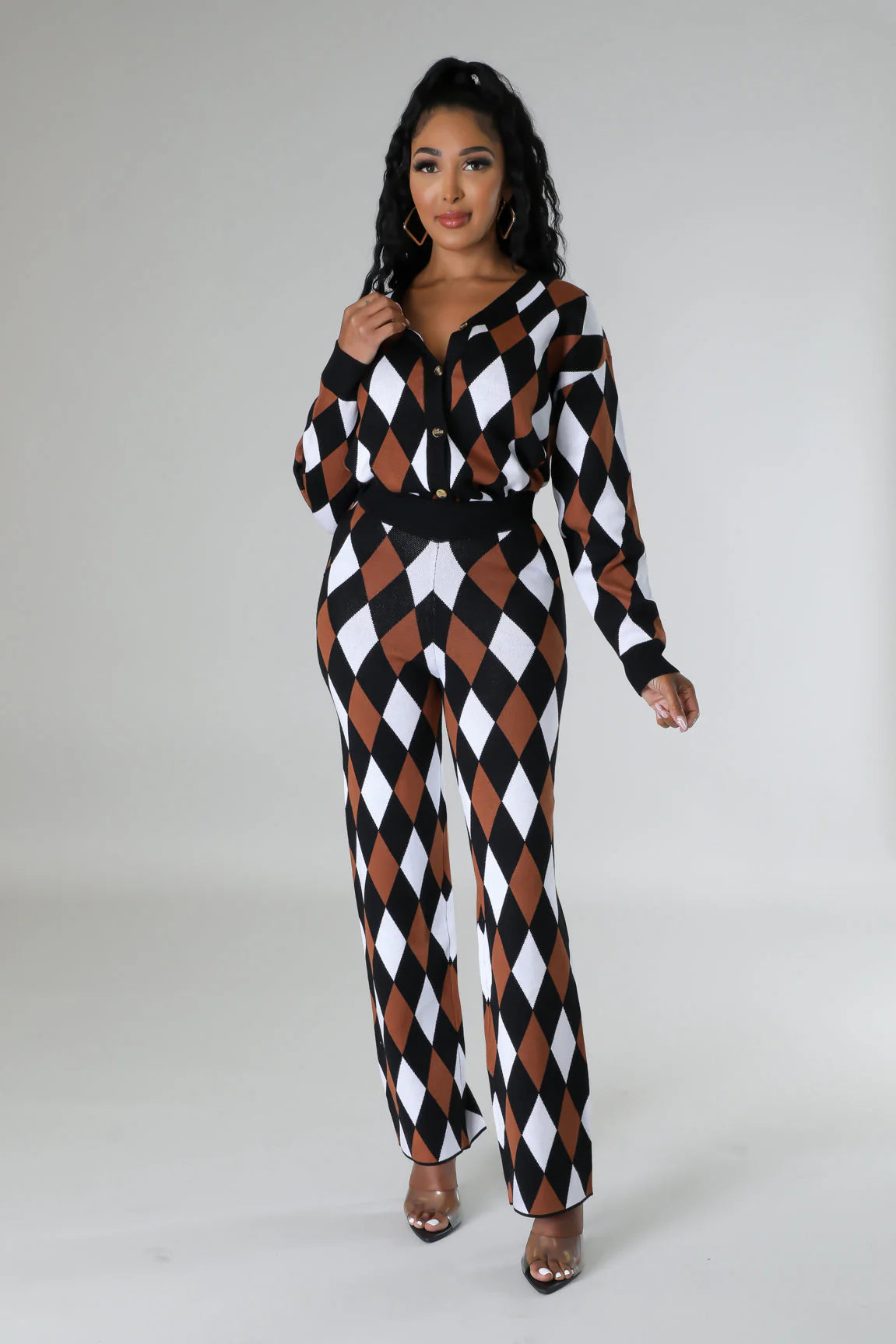 woman wearing a black, white, and brown checkered jumpsuit on a gray background