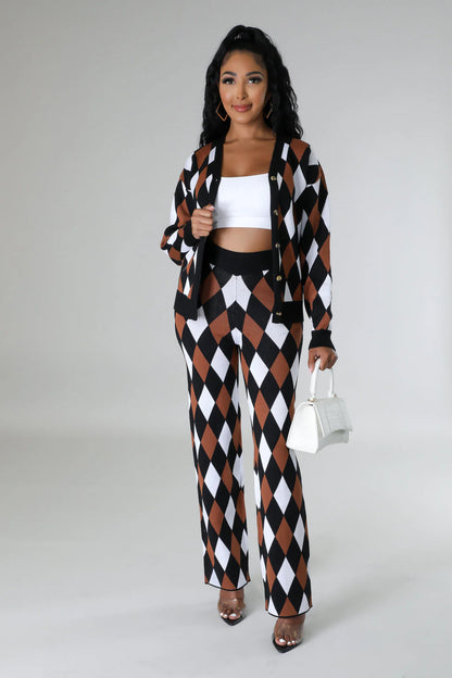 Woman wearing a black, white, and brown checkered outfit with a white top and holding a white handbag.