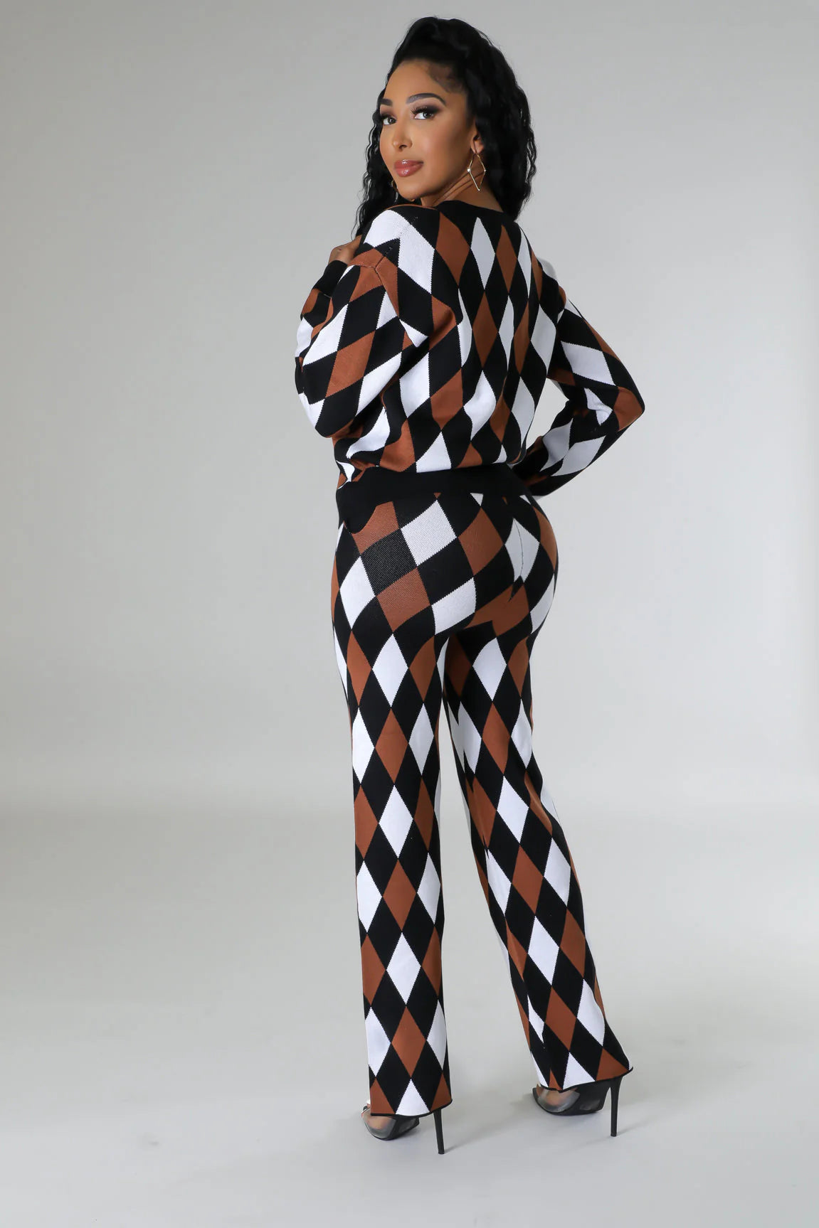 person wearing a harlequin pattern jumpsuit on a plain background