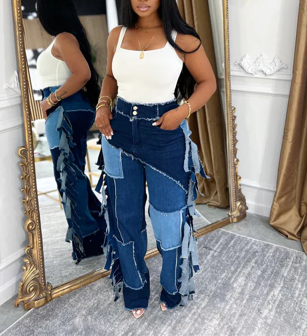 woman wearing a unique denim outfit with ruffled details in front of a large mirror.