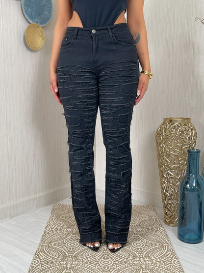 Person wearing dark blue distressed jeans standing in a room with decorative elements.